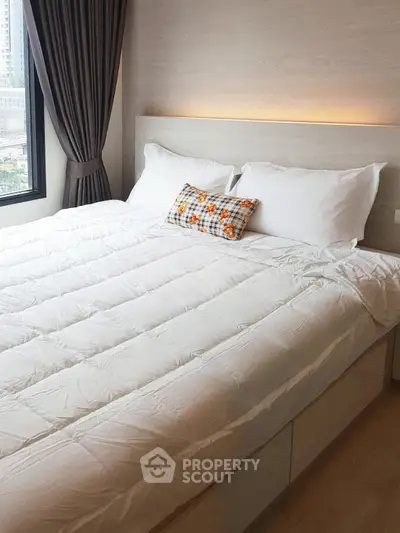Cozy modern bedroom with large window and stylish decor in urban apartment.