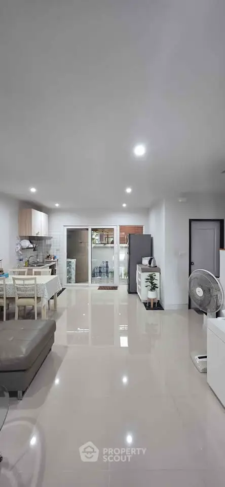 Spacious modern living room with open kitchen and sleek furnishings.