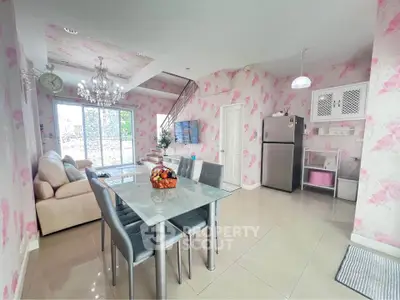 Charming open-plan living and dining area with floral wallpaper and modern furnishings.