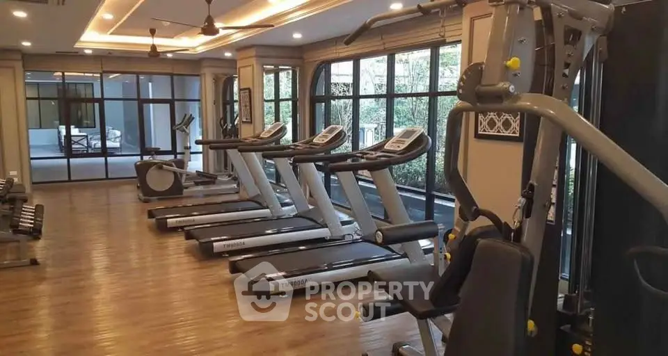 Modern gym with state-of-the-art equipment and large windows for natural light.