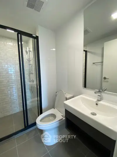 Modern bathroom with sleek shower and elegant fixtures in contemporary apartment.