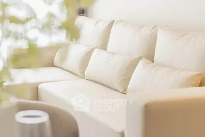 Elegant cream-colored sofa in a bright, modern living room setting.