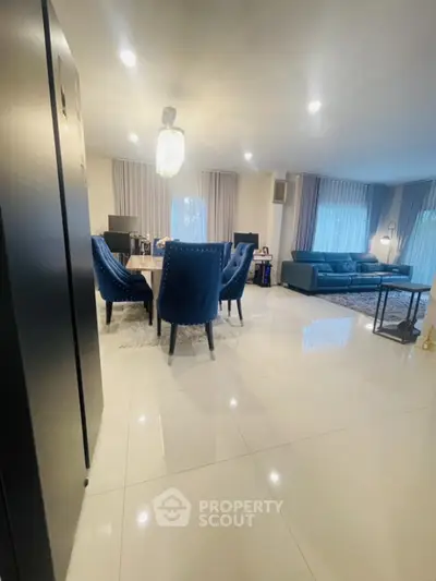 Spacious modern living room with elegant blue chairs and luxurious lighting