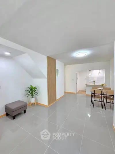 Modern open-plan living area with sleek tile flooring and stylish dining setup