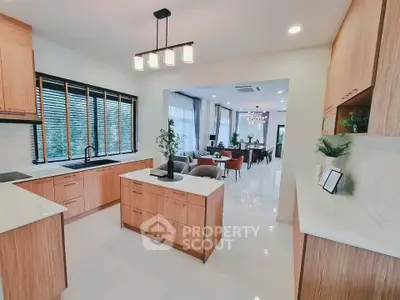 Modern kitchen with open layout and elegant dining area, featuring sleek cabinetry and stylish lighting.