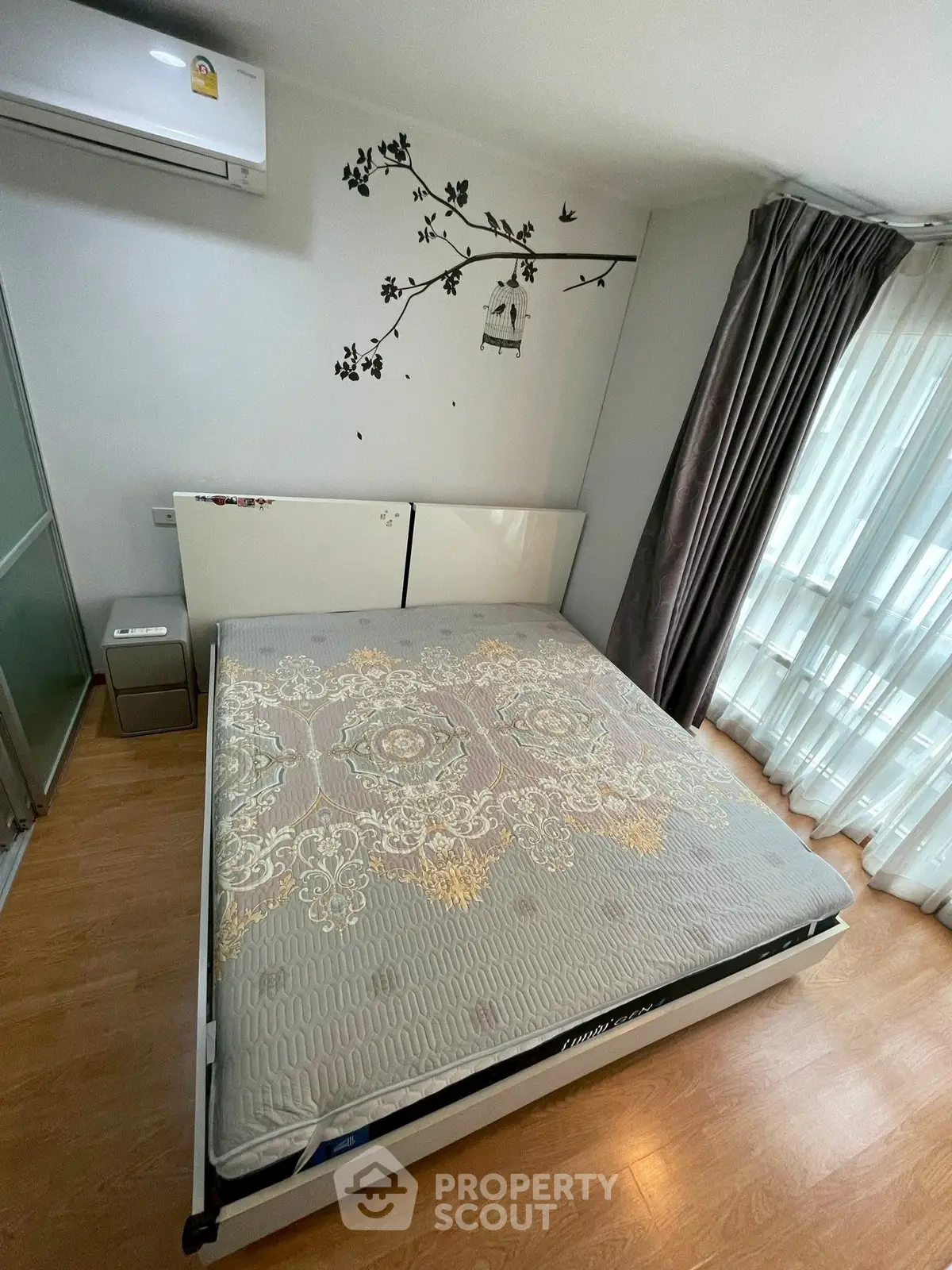 Cozy bedroom with stylish decor and natural light, featuring a comfortable bed and elegant curtains.