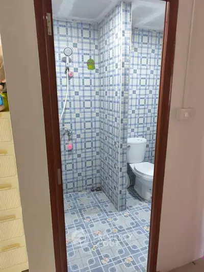 Compact bathroom with blue mosaic tiles and modern fixtures