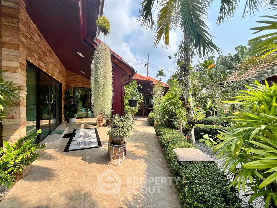 Charming tropical garden entrance with lush greenery and elegant stone pathway
