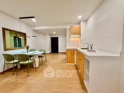 Modern open-plan kitchen and dining area with stylish decor and wooden flooring.