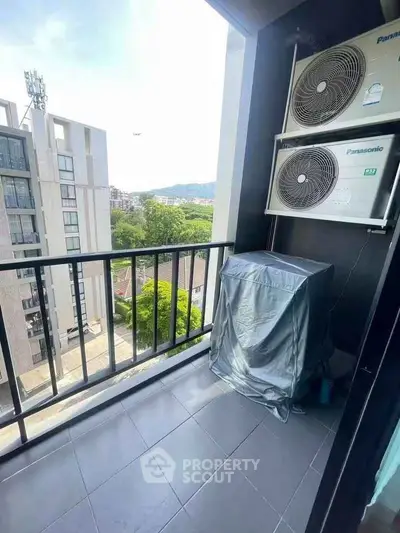 Modern balcony with air conditioning units and scenic view in urban setting.