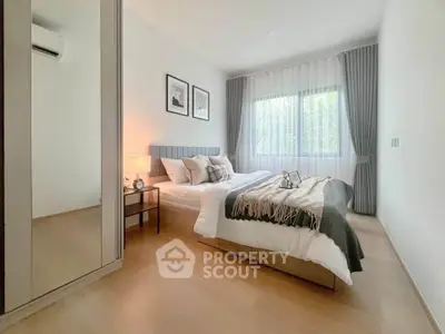 Modern bedroom with cozy decor and natural light in a stylish apartment.