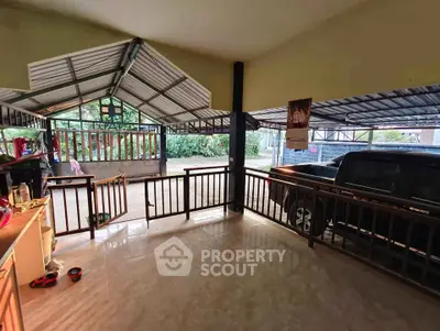 Spacious covered parking area with tiled flooring and open view, ideal for multiple vehicles.