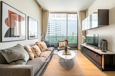 Modern living room with stylish decor and city view, featuring a comfortable sofa and elegant furnishings.