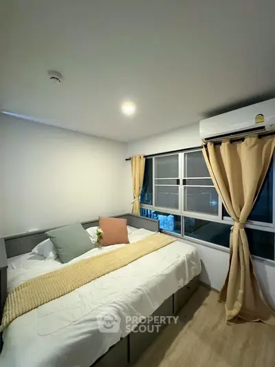 Cozy bedroom with large window and modern decor in a stylish apartment.