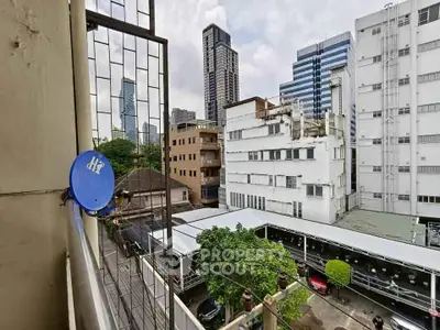 Urban balcony view with city skyline and parking area, perfect for city living enthusiasts.
