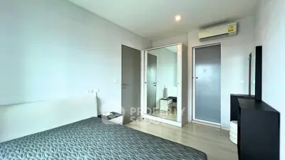 Modern bedroom with sleek design, featuring a mirrored wardrobe and air conditioning for comfort.