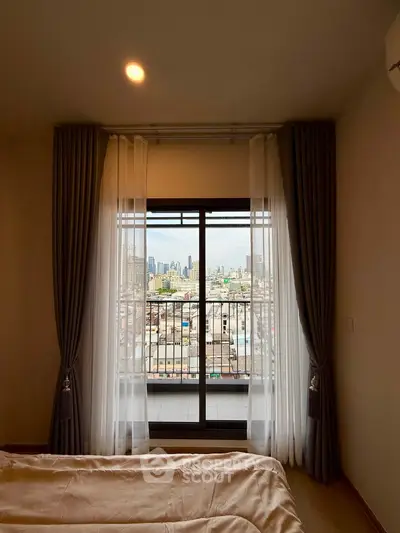 Stunning bedroom with city view through large window and elegant curtains.