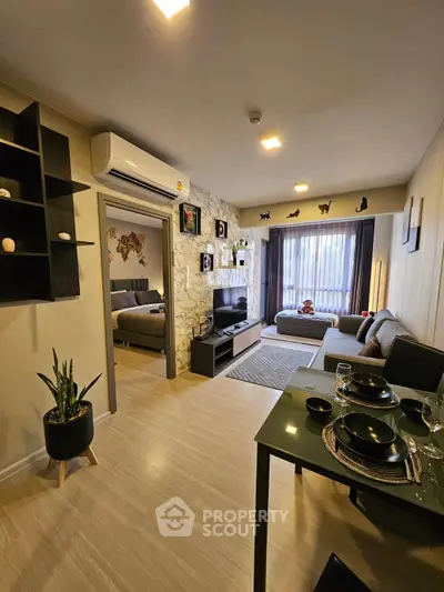 Modern living room with stylish decor and open layout leading to a cozy bedroom, perfect for urban living.