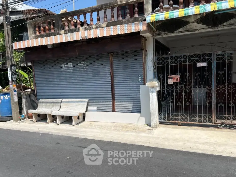 Charming street view of a traditional building with unique architectural details and potential for renovation.
