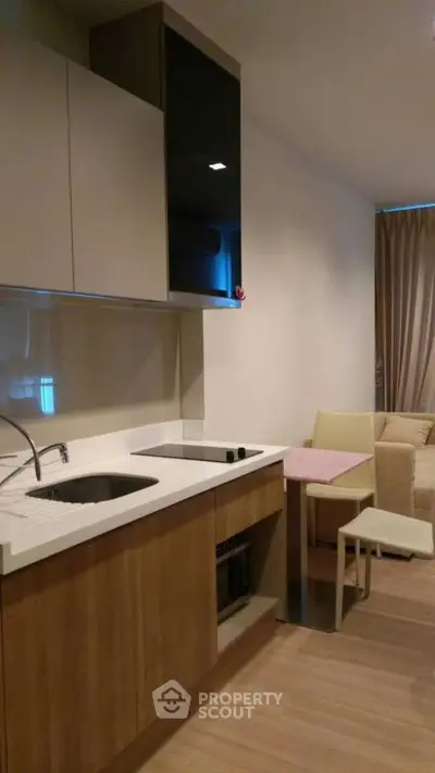 Modern kitchen with sleek cabinetry and cozy dining area in stylish apartment