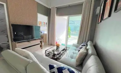 Modern living room with stylish decor and large TV, featuring a cozy white sofa and natural light.