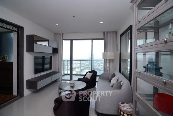 Modern living room with large windows and stylish furniture in a high-rise apartment.