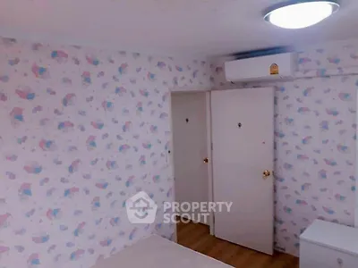 Cozy bedroom with whimsical wallpaper design, built-in closet, and modern air conditioning unit, perfect for comfortable living.
