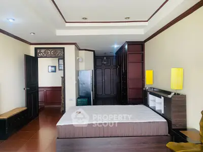 Spacious bedroom with elegant wooden furnishings and modern lighting in a stylish apartment.