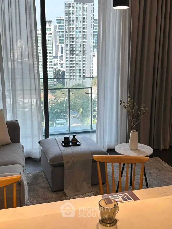 Modern living room with city view, elegant decor, and cozy seating area.