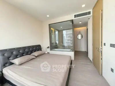 Modern bedroom with glass wall and ensuite bathroom in luxury apartment