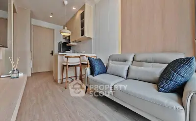 Modern living room with cozy sofa and open kitchen layout in stylish apartment.