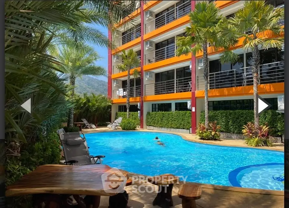 Luxurious apartment complex with stunning pool and lush palm trees