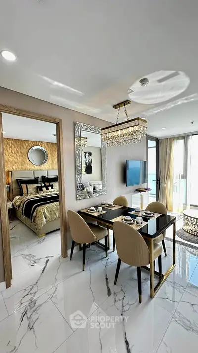 Luxurious open-plan dining and living area with elegant decor and marble flooring, adjacent to a stylish bedroom.