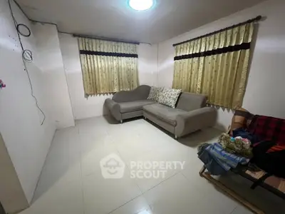 Cozy living room with modern sofa and tiled flooring, perfect for relaxation.