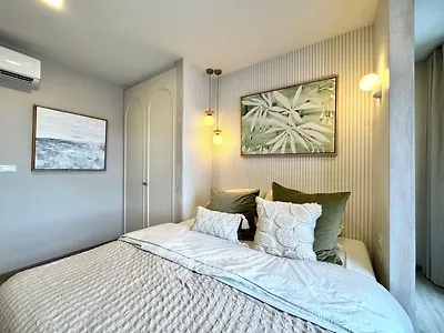Modern bedroom with stylish decor and cozy ambiance, featuring elegant lighting and framed artwork.