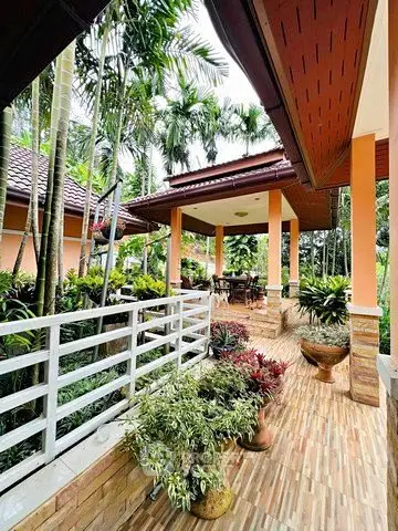 Charming tropical garden entrance with lush greenery and inviting patio area