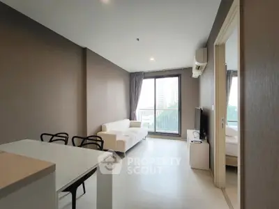 Modern living room with sleek furniture and large window offering city view