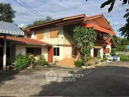 Charming two-story house with lush greenery and spacious driveway