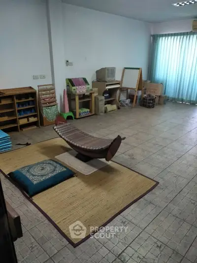 Spacious room with tiled floor, natural light, and versatile setup for creative or educational use.