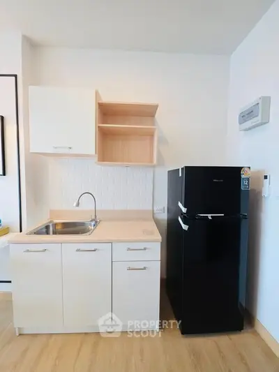 Modern kitchen with sleek black fridge and minimalist cabinetry