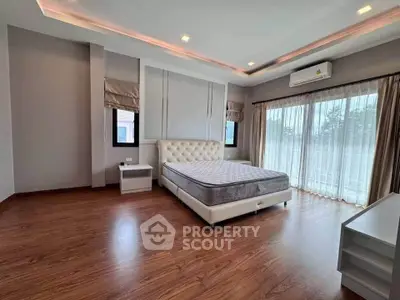 Spacious bedroom with elegant design and large windows for natural light.