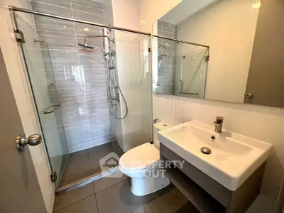 Modern bathroom with glass shower and sleek fixtures in a contemporary home.