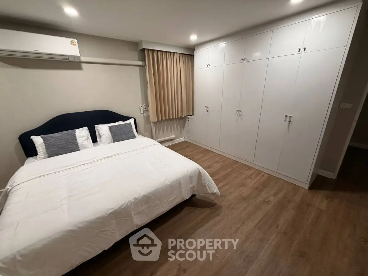 Spacious bedroom with modern design and ample storage in a stylish apartment.