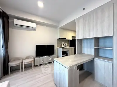 Modern living room with sleek furniture and integrated kitchen area, featuring neutral tones and ample storage.