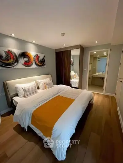 Modern bedroom with stylish decor and ensuite bathroom in a luxury apartment.