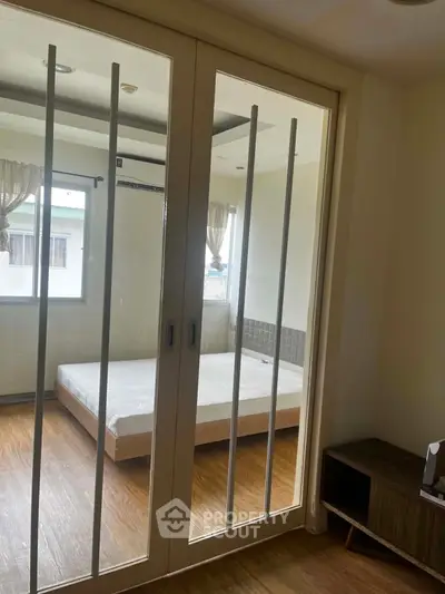 Spacious bedroom with sliding glass doors and natural light, perfect for modern living.