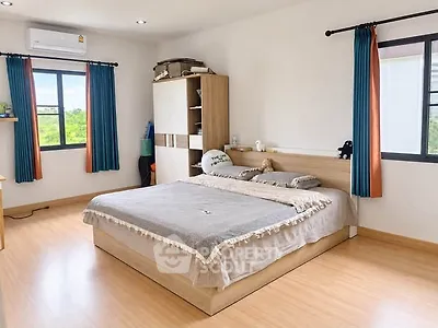 Spacious bedroom with large windows and modern furnishings, offering a bright and inviting atmosphere.