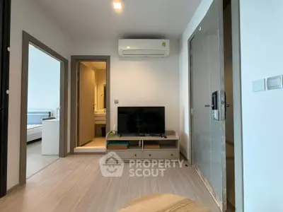 Modern apartment interior with living room and bedroom view, featuring sleek furniture and air conditioning.