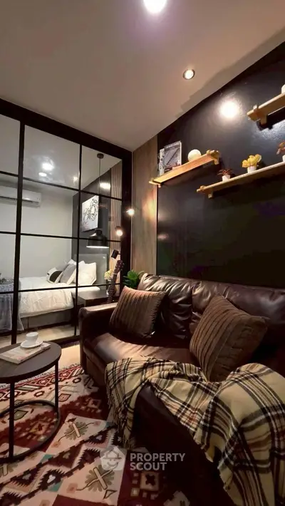 Cozy living room with modern decor and glass partition leading to bedroom.