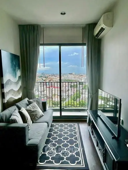 Stylish living room with city view from large window, modern decor and cozy seating.